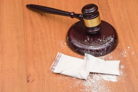 White powder on the judge's gavel. Drugs on the table of the judge. Court for the sale of drugs. Verdict for the distribution of drugs. の写真素材