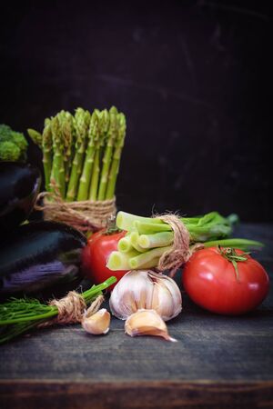 Beautiful still life with a low key. Unusual light from the window on raw and fresh vegetables lying in a pile on the shelf.の写真素材