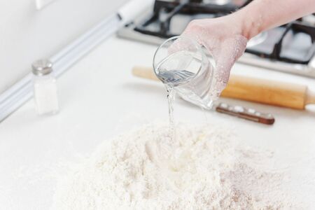 Hands chef knead dough for pizza. Knead dough with your hands. Woman's hands knead dough. Cooking pizza. の写真素材