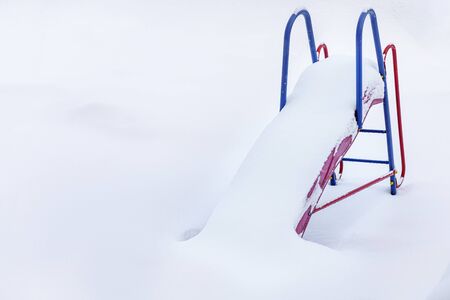  Winter, hill, snow and frost. Children's slide in the snow in winter. Snow-covered hill background of white snow. Snow slide for skiing frosty day. Place for spears on a background of white snow.の写真素材