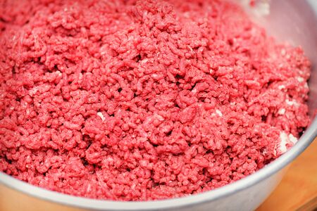 Minced meat. Advertising of fresh minced meat in minced meat close up.  Chopped meat through manual meat grinder close-up. Copy space on the background of ground beef. Cooking minced meat from fresh meat, background for the store. の写真素材