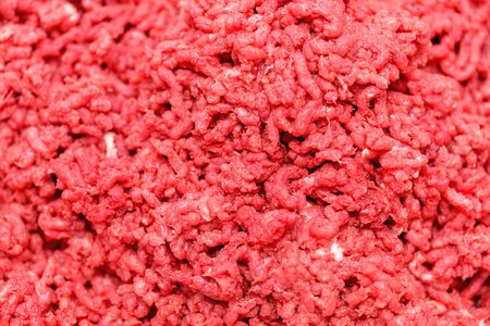 Minced meat.  Chopped meat through manual meat grinder close-up. Copy space on the background of ground beef. Cooking minced meat from fresh meat, background for the store. Advertising of fresh minced meat in minced meat close up.の写真素材