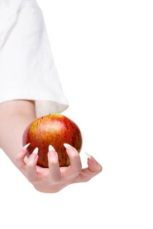Hand of young woman with natural nails holds natural apple. Healthy eating concept. White background close-up apple. More natural nails, concept healthy lifestyle. Caring for the health of hands and nails. Woman Hands Natural Nails, closeup. Beautiful female hand holds an apple.の写真素材