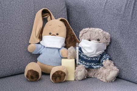 Coronovirus outbreak in world. Wear medical masks and wash your hands more often. Soft toy bunny and bear in medical masks and soap in paws to protect against the virus. Means of protection against the virus, visual aid for children.の写真素材
