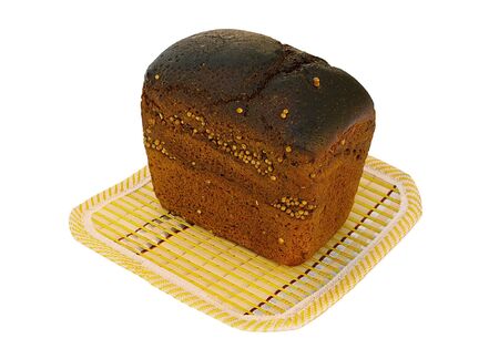 Loaf of rye bread with caraway on a yellow bamboo mat 