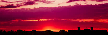 Silhouette of the roofs of houses at sunset.の写真素材