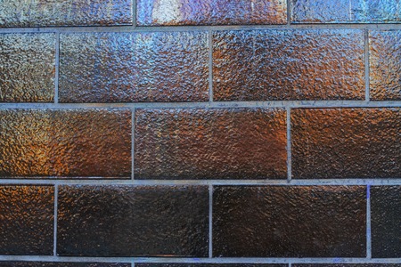 Texture reflective tiles on the wall of a dark brown colorの写真素材