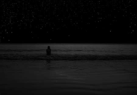 girl in the sea against the starry skyの写真素材