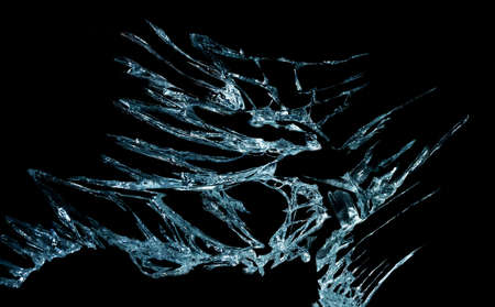 broken mirror glass on a black background in cracks in the form of an isolated image abstractionの写真素材