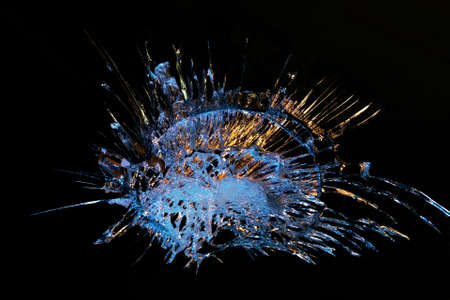 broken mirror glass on a black background in cracks in the form of an isolated image abstractionの写真素材