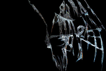 broken mirror glass on a black background in cracks in the form of an isolated image abstractionの写真素材
