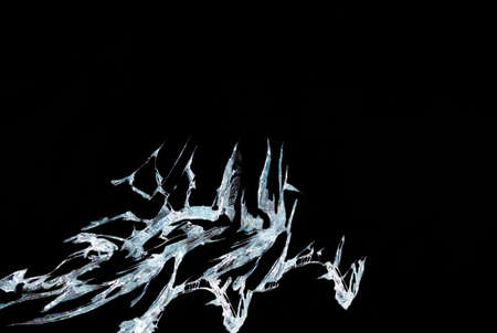 broken mirror glass on a black background in cracks in the form of an isolated image abstractionの写真素材