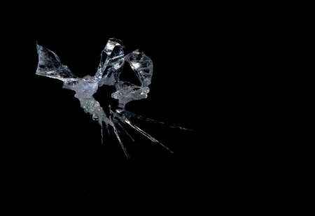 broken mirror glass cracks in the form of lines and abstractions on an isolated black backgroundの写真素材