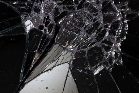 broken mirror glass cracks in the form of lines and abstractions on an isolated black backgroundの写真素材