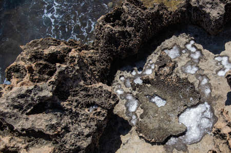 the rocky seashore in the form of rocks and depressions, against the background of the rock, as an abstraction, the image and patterns of nature on the stonesの写真素材