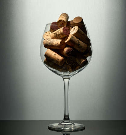Empty wine glass full of wine corks