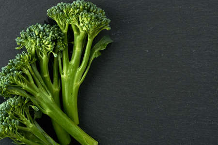 Small broccoli on a black stone table. Image can be used as a texture as well, I left some space for the text on the right side.の写真素材