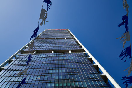 17.04.2021.Tel-Aviv, Israel. Electra tower against the blue sky with the white blue flags in front.