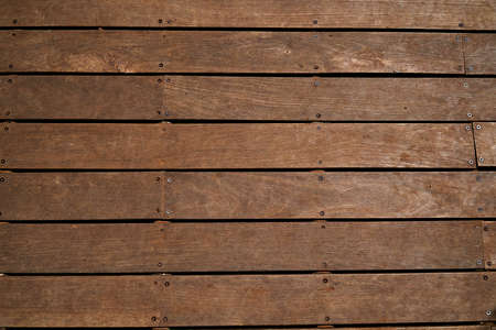 Brown wooden background texture. Looks like a floor or the top of the wooden table or fence.