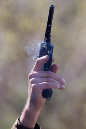 revolver in hand immediately after the shotの写真素材