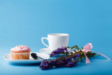 Colorful muffin on saucer with flowersの写真素材