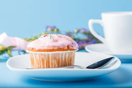 Colorful muffin on saucer with flowersの写真素材