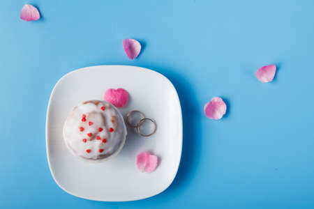 Colorful muffin on saucer with wedding ringsの写真素材