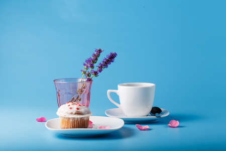 Colorful muffin on saucer with flower petalの写真素材