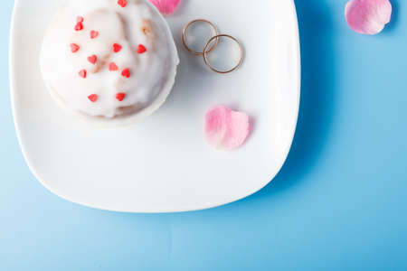 Colorful muffin on saucer with wedding ringsの写真素材