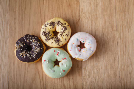 Colored donuts on wood tableの写真素材