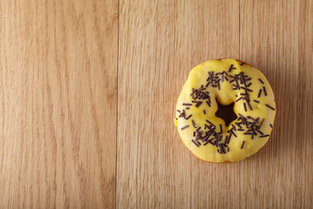 Yellow donut on wood tableの写真素材