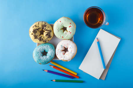 Donuts with tea and open sketchbookの写真素材