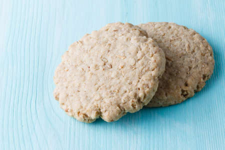 Two oat cookies on aquamarine backgroundの写真素材