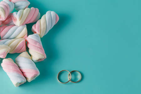 Twisted marshmallow on vibrant background. Wedding decoration golden ringsの写真素材