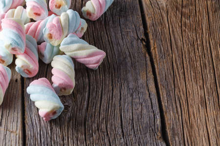 Twisted colored marshmallows on wooden tableの写真素材