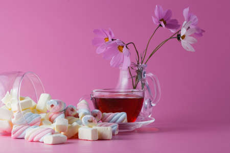 Color marshmallow dropped out. Tea cup and flowersの写真素材