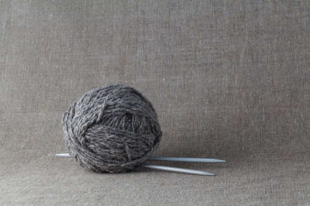 Clew of gray homemade wool yarn with needleの写真素材