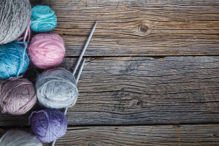 Colored wool clew on rustic wooden background
