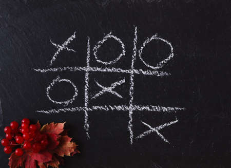 Game Tic Tac Toe on black slate boardの写真素材