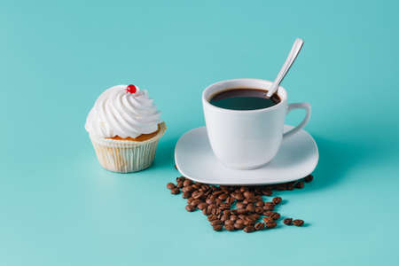 colorful pink cupcake on aquamarine background with coffee cupの写真素材