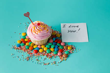 Birthday present. One cupcake on aquamarine backgroundの写真素材