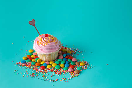 Birthday present. One cupcake on aquamarine backgroundの写真素材