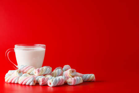 Heap of sweets marshmallow with milk on plain red backgroundの写真素材