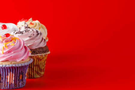 Colored cupcake with tea cup on brigth red backgroundの写真素材