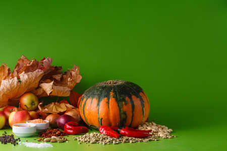 Fall harvesting.  Pumpkin with onion and pepper on green shadowless backgroudの写真素材