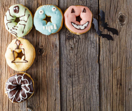 Halloween donuts on rustic wooden tableの写真素材