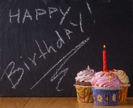 Sweets with copy space on black slate background. Donuts and cupcakesの写真素材
