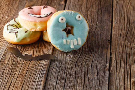 Halloween donuts on rustic wooden tableの写真素材