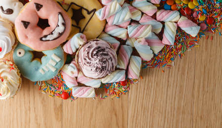 Fun frame with sweets on wooden table. Heap of twisted marshmallowの写真素材
