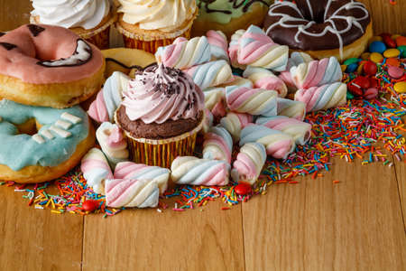 Fun frame with sweets on wooden table. Heap of twisted marshmallowの写真素材